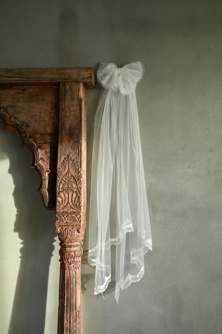 Suknia ślubna z długim tiulowym trenem i dużą kokardą.