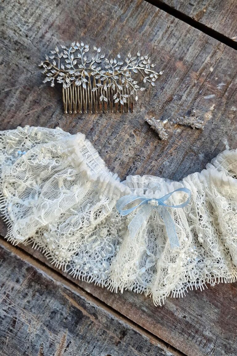 Suknia z koronkowymi detalami i ozdobnym grzebieniem do włosów.