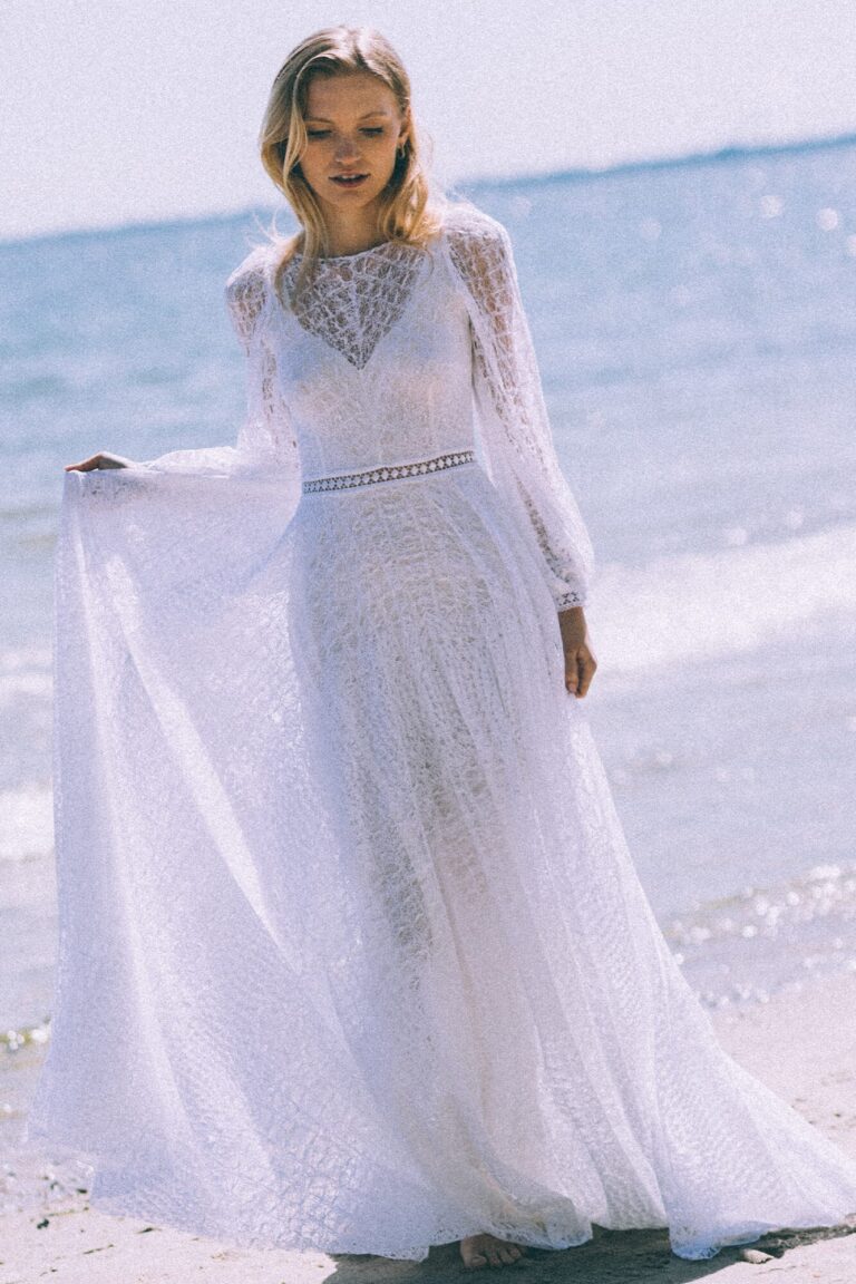 Suknia ślubna z długimi rękawami i trenem, wykonana z tiulu.