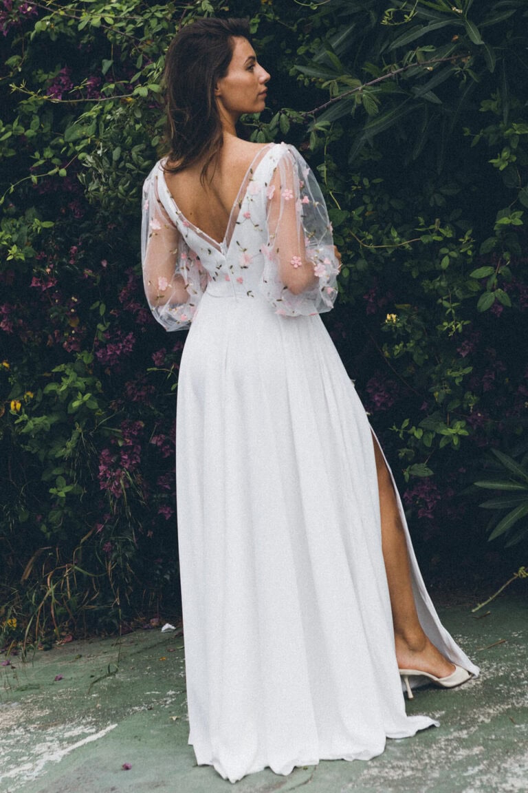 Suknia z długimi koronkowymi rękawami i odkrytymi plecami z rozcięciem.