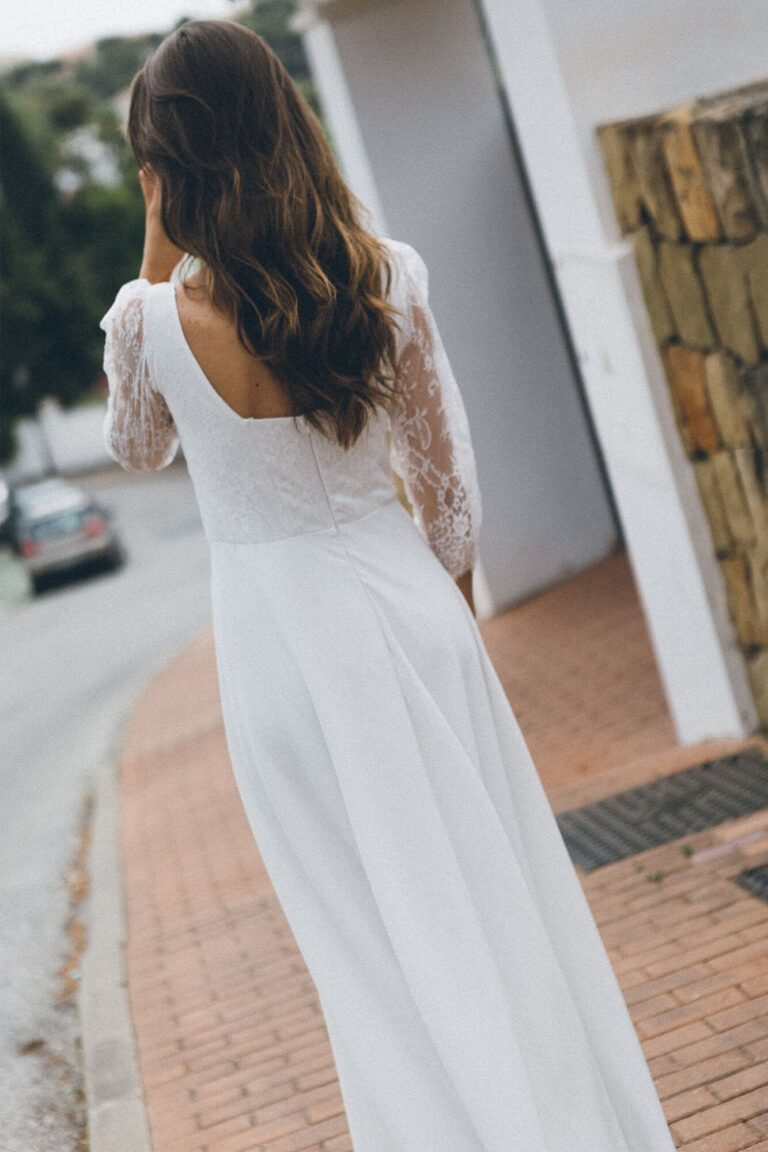 Suknia z odkrytymi plecami i długimi rękawami z koronki.