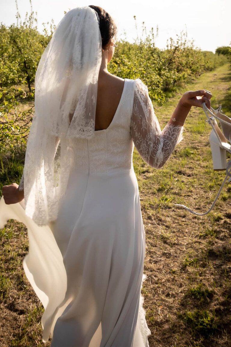 Suknia ślubna z odkrytymi plecami i długim trenem, widziana z tyłu.