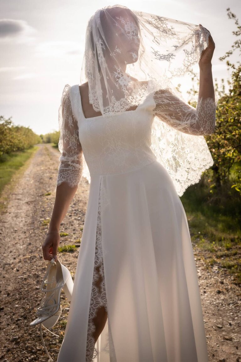 Suknia z długimi koronkowymi rękawami i dekoltem w kształcie litery V.