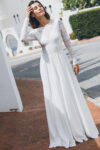 Suknia z długimi rękawami i rozkloszowanym dołem w białym kolorze.