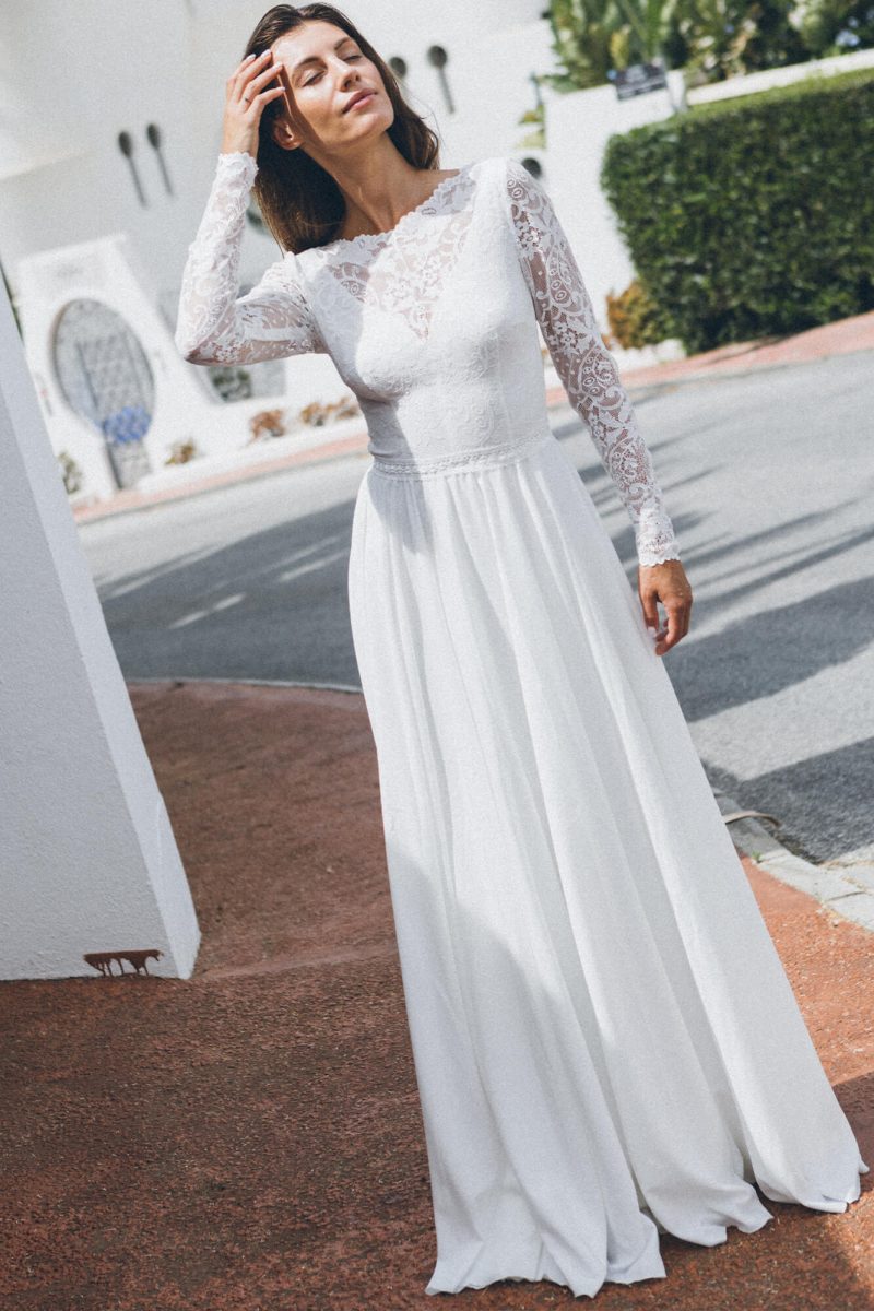 Suknia z długimi rękawami i rozkloszowanym dołem w kolorze białym.