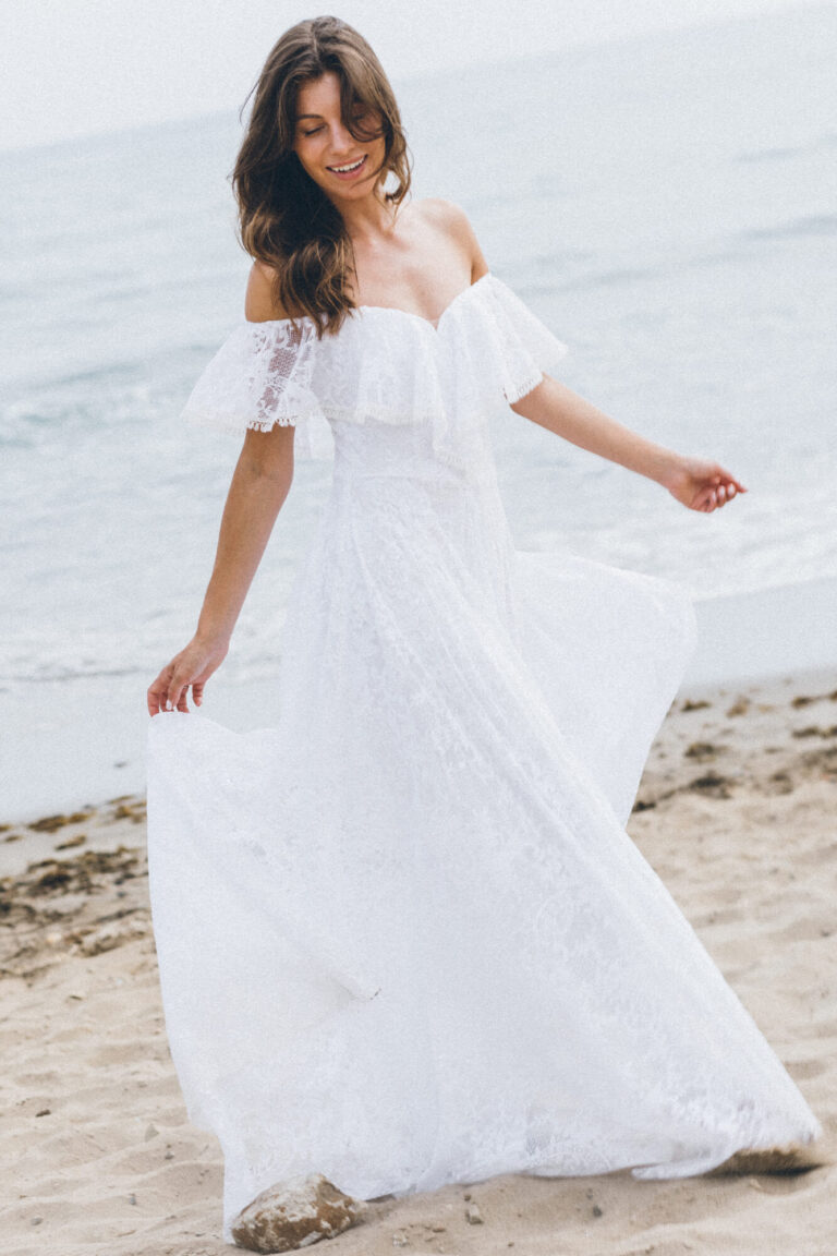 Suknia z odkrytymi ramionami i długim, zwiewnym dołem.