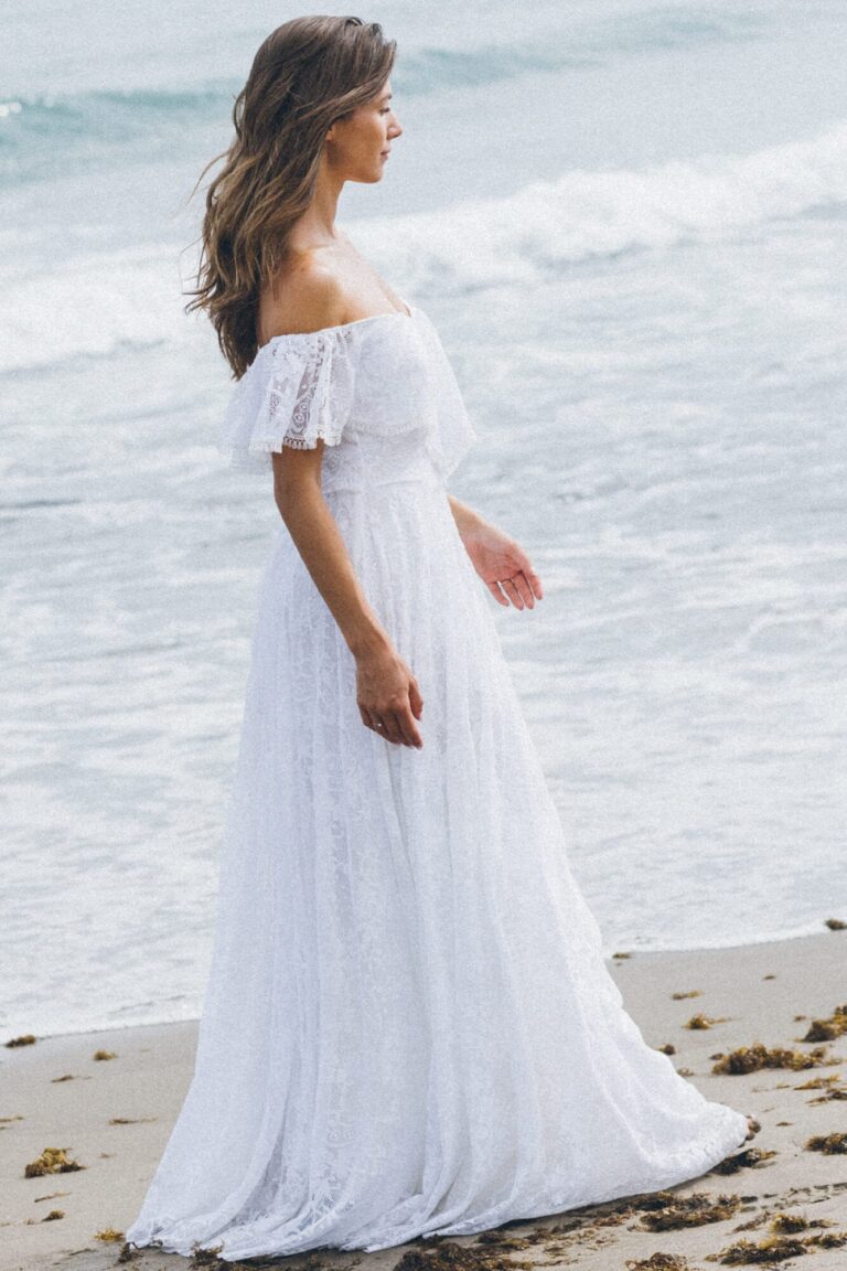 Suknia z odkrytymi ramionami i długim, zwiewnym dołem.