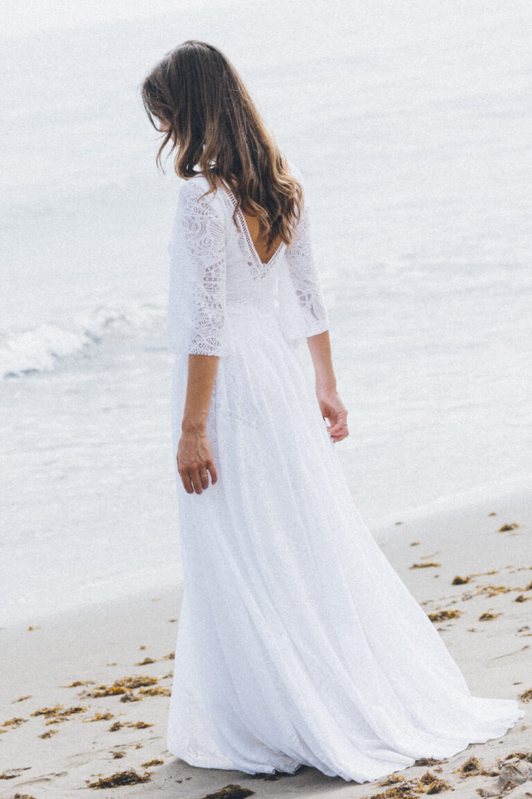 Suknia ślubna z długimi rękawami i odkrytymi plecami widoczna z tyłu.