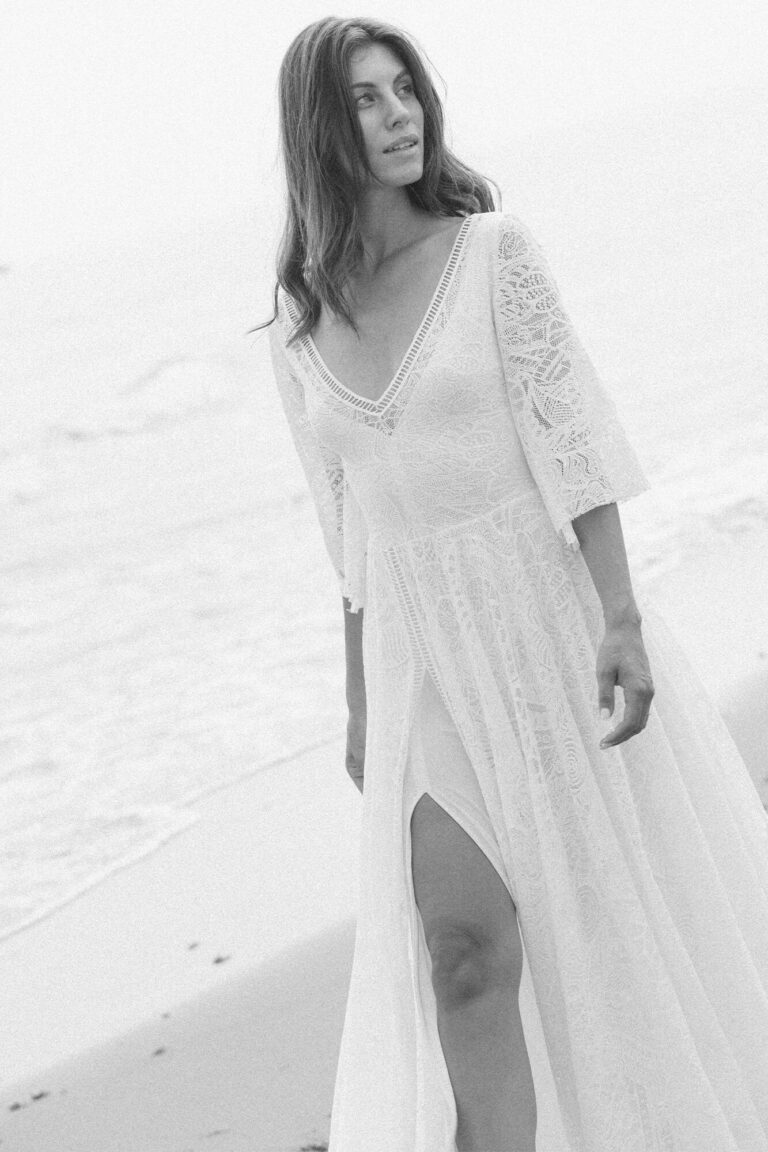 Suknia z dekoltem w serek, długimi rękawami i rozcięciem na nodze.