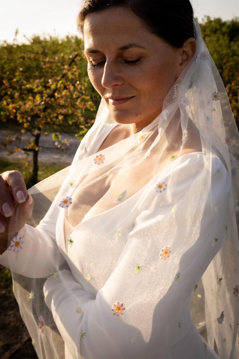 Suknia z długimi rękawami i koronkowym wykończeniem, widoczny delikatny materiał.