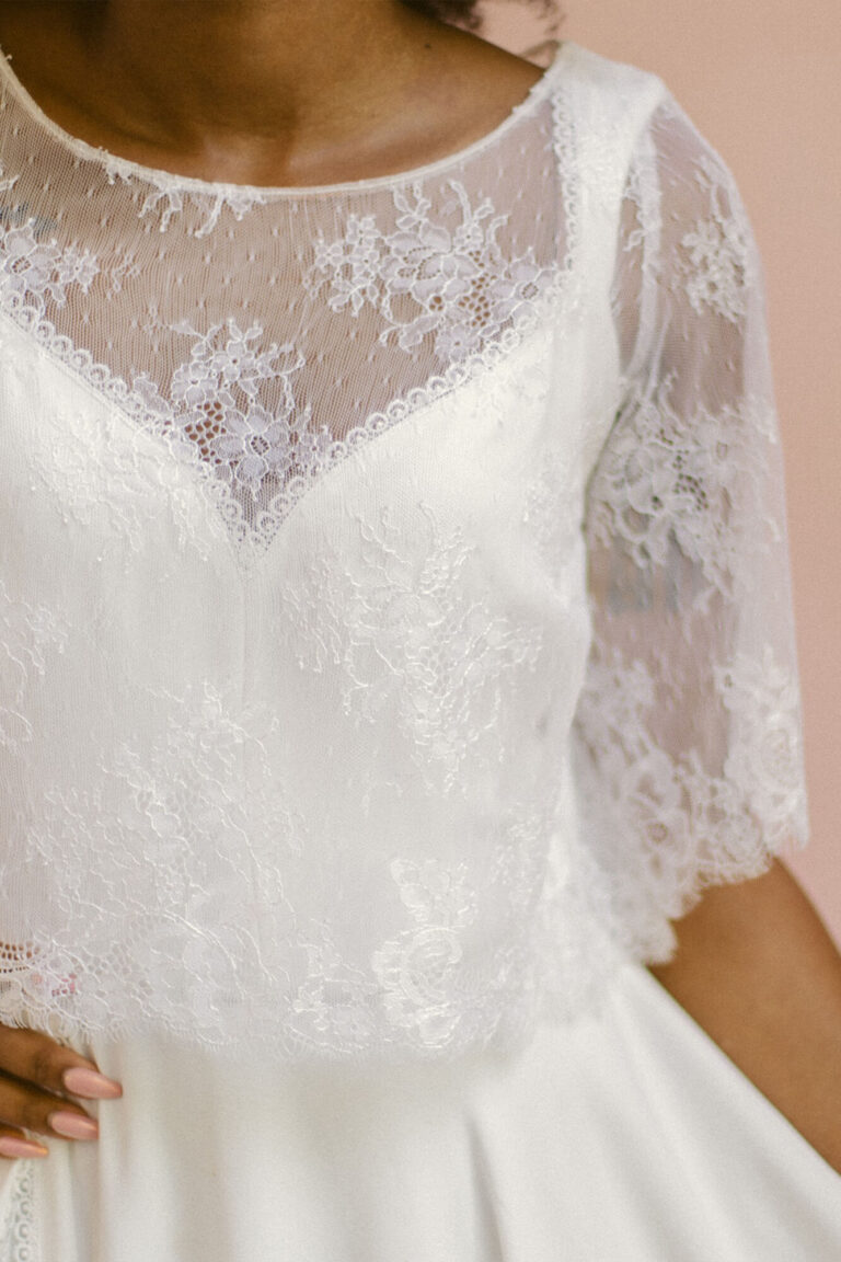 Suknia ślubna z koronkowymi rękawami i dekoltem w kształcie litery V.