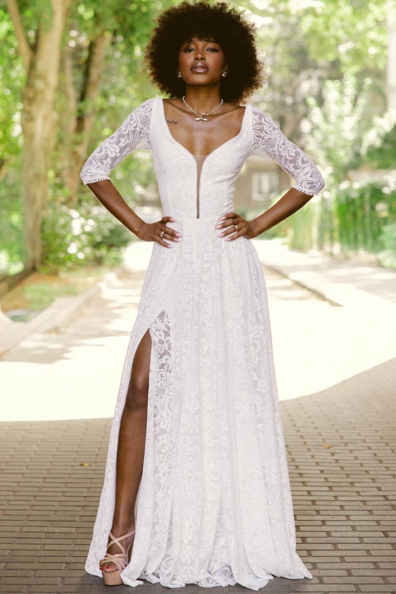 Suknia z długimi koronkowymi rękawami, dekoltem w serek i rozcięciem na udzie.